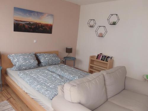 a bedroom with a white bed and a couch at Ferienwohnung Palatina Annweiler in Annweiler am Trifels