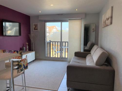 un salon avec un canapé et une salle à manger dans l'établissement 2 pièces Les Coquillages - Hypercentre et Plage, à Houlgate