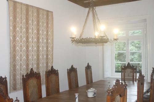 uma sala de jantar com uma mesa e cadeiras e um lustre em Tapada Nacional de Mafra em Mafra