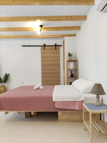 um quarto com uma cama grande e uma porta de madeira em Zaira's Apartment Corfu Town em Ágios Rókkos