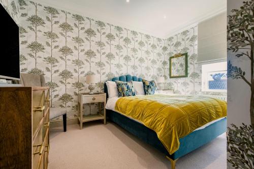a bedroom with a bed with a yellow bedspread at Derwent House Apartments in Scarborough