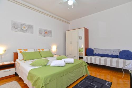 ein Schlafzimmer mit einem großen Bett mit grünen Kissen in der Unterkunft Apartment Silvio 1779 in Banjole