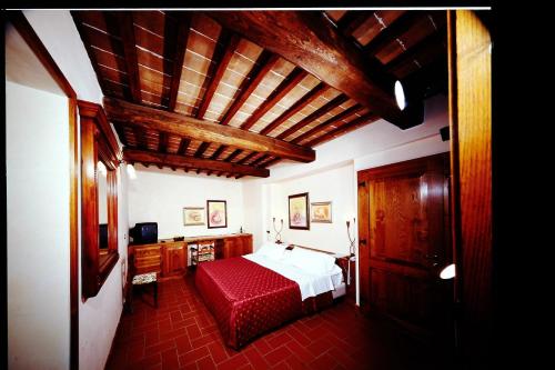a bedroom with a large bed with a red blanket at Fattoria Pianetti in Manciano