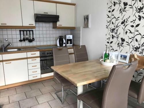 a kitchen with a wooden table and chairs in it at Ferienwohnung Buhne 33 in Hooksiel