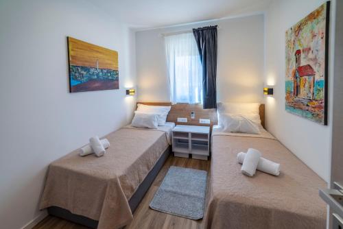 a small room with two beds and a window at PINNA RESIDENCE - VANGA in Pula