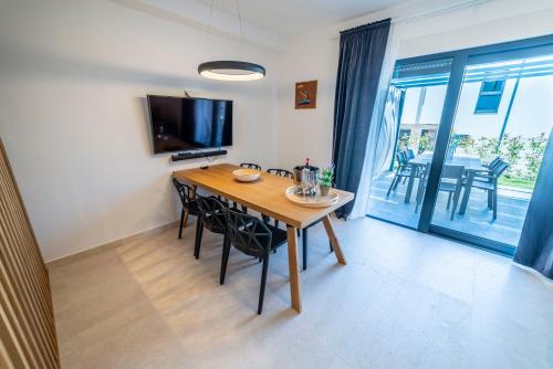a dining room with a table and chairs and a television at PINNA RESIDENCE - VANGA in Pula