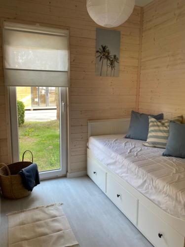 a bedroom with a bed with a large window at Seaside Harmony in Pogorzelica
