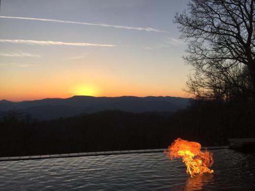 a fire pit with the sunset in the background at Fire Mountain in Highlands