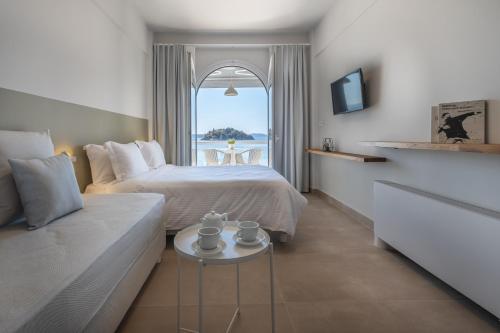 a bedroom with a bed and a couch and a window at Nelly's Apartments in Tolo