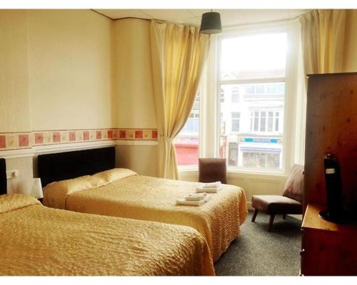 a hotel room with two beds and a window at St Elmo Hotel in Blackpool