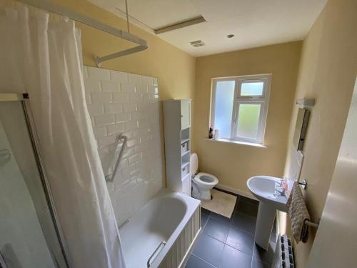 a bathroom with a tub and a toilet and a sink at 2 BED WATERFRONT PROPERTY - CLOSE TO COURTMACSHERRY in Cork