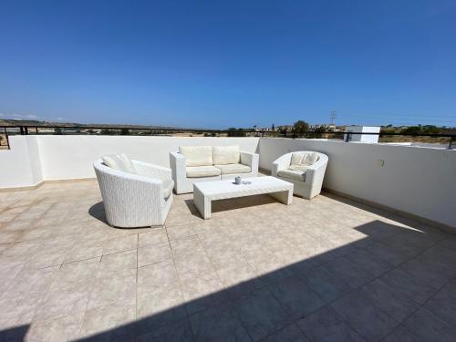 a patio with two chairs and a table on a roof at Pyla Palms A1 204 in Pyla