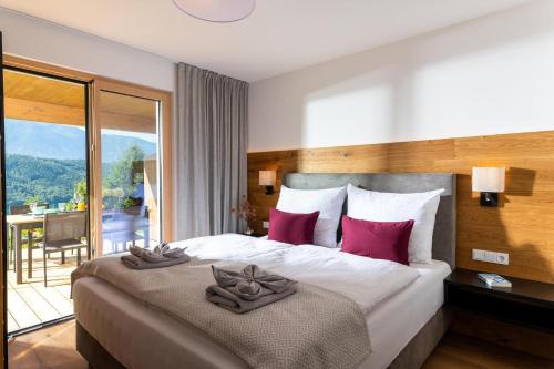 una habitación de hotel con una cama con almohadas rojas. en Chalet Seeblick, en Millstatt