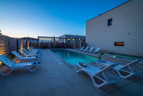 a swimming pool with lounge chairs next to a building at PINNA RESIDENCE - VANGA in Pula