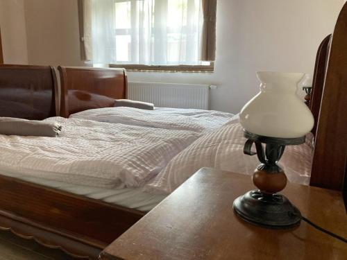 a lamp sitting on a table next to a bed at Kisdió Vendégház in Dég