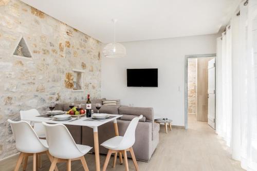 un soggiorno bianco con tavolo e sedie di The Stone House Naxos a Glinado Naxos