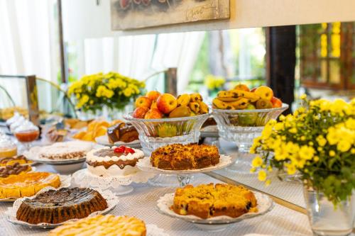 a table with cakes and other desserts on plates at Casablanca Hotel Boutique in Campos do Jordão