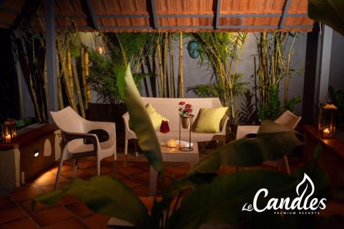 a living room with a table and chairs and plants at Le Candles Resort in Kozhikode
