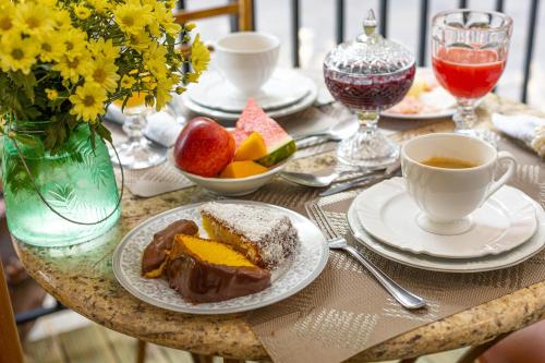 a table with a plate of cake and a cup of coffee at Casablanca Hotel Boutique in Campos do Jordão