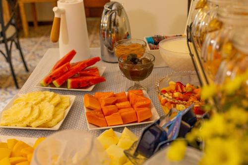 a table topped with different types of fruits and vegetables at Casablanca Hotel Boutique in Campos do Jordão