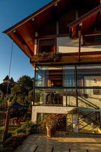 a house with a balcony with a table on it at Casablanca Hotel Boutique in Campos do Jordão