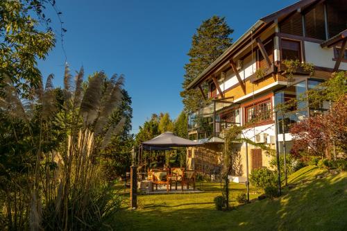 a house with a garden in front of it at Casablanca Hotel Boutique in Campos do Jordão