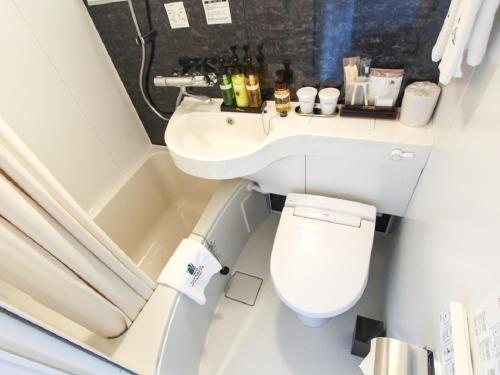 uma casa de banho com um WC, um lavatório e uma banheira em HOTEL LiVEMAX Okayama West em Okayama