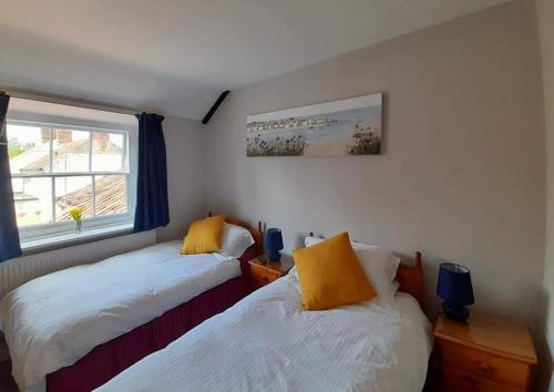two beds in a small room with a window at The Bell Inn in Norwich