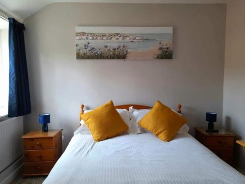 a bedroom with a bed with two yellow pillows at The Bell Inn in Norwich