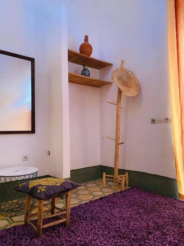 a room with a table and a chair and shelves at house rose in Marrakech