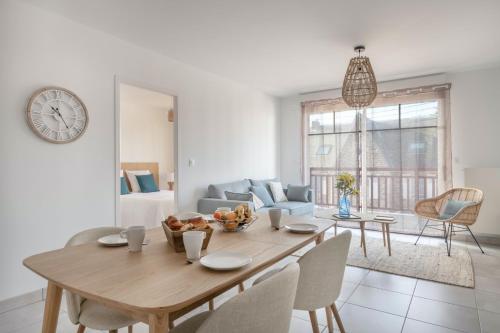 une salle à manger avec une table et un salon dans l'établissement À 50m de la plage, appartement vue mer 6 pers, à Pléneuf-Val-André