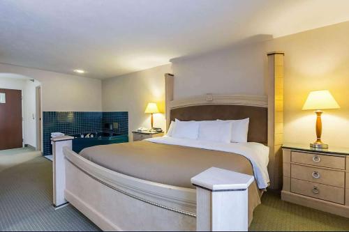 a large bedroom with a large bed and two lamps at Baymont by Wyndham Omaha SW in Omaha