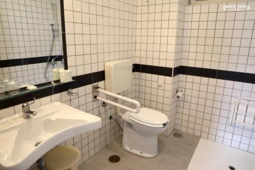 a bathroom with a white toilet and a sink at Jazz Hotel in Naples