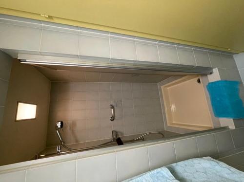 ein Bad mit einem Spiegel und ein Bett in einem Zimmer in der Unterkunft Studio Neptun 4 im Zentrum von Bad Ragaz in Bad Ragaz