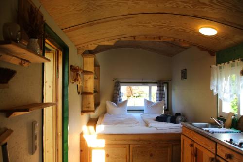 Bett in einem Zimmer mit Fenster in der Unterkunft Dom Žaba - Spreewaldatmosphäre im neu renovierten Bauwagen in Burg