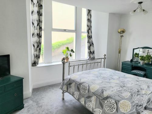 a bedroom with a bed and a window at Loveliest Homes Torquay - 3 bed, 2 bathroom, balcony, parking in Torquay