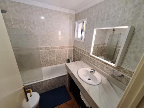 een badkamer met een wastafel, een spiegel en een bad bij La Quinta Relax in Santa Úrsula