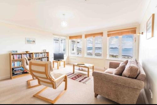 a living room with a couch and a chair at Fantastic spacious house with beautiful panoramic views of the bay Only a few minutes walk from beach harbour and restaurants This house has 3 bedrooms 3 bathrooms and 2 lovely sitting rooms in Lyme Regis