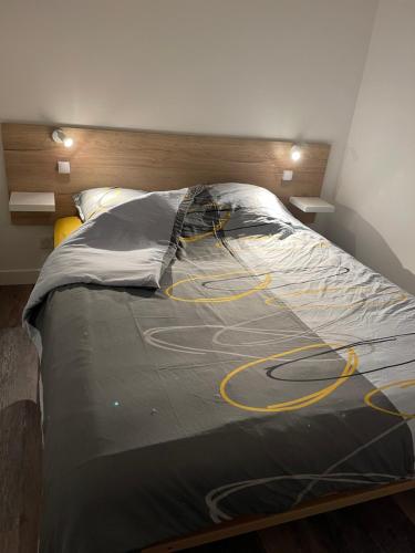 uma cama grande num quarto com cordões amarelos em Le 33 em Belfort