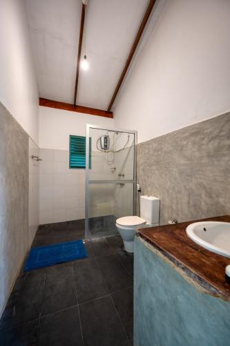 a bathroom with a shower and a toilet and a sink at Hide Yala in Tissamaharama
