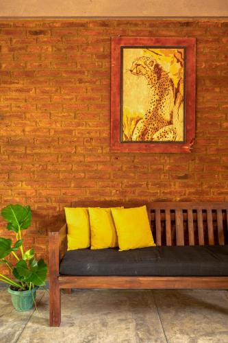 a bench with two yellow pillows on a brick wall at Hide Yala in Tissamaharama