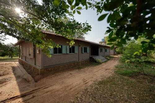 a house on a dirt road next to a house at Hide Yala in Tissamaharama