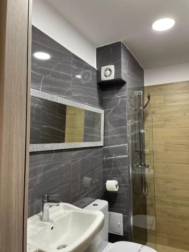 a bathroom with a toilet and a sink and a shower at Hotel Unirea in Mamaia