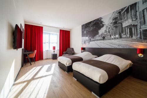 two beds in a hotel room with red curtains at Bastion Hotel Arnhem in Arnhem
