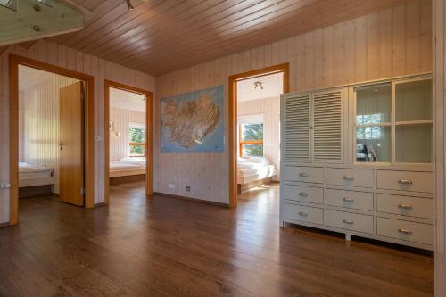 a large room with a dresser and a bedroom at Gorgeous Riverside Lodge in the South of Iceland in Reykholt