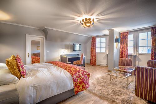 a bedroom with a bed and a desk at Parkhotel Adler in Hinterzarten