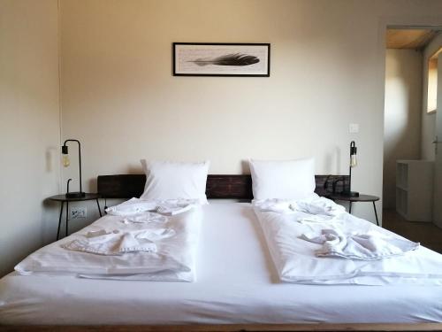 a large white bed with white sheets and pillows at Easy-Living Kriens Apartments in Luzern