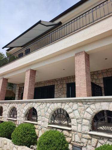 a house with a stone wall and a roof at Biuk Apartments in Novi Vinodolski