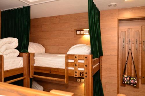 1 Schlafzimmer mit 2 Etagenbetten und grünen Vorhängen in der Unterkunft Music Hostel in Poltawa