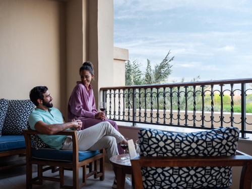 a man and a woman sitting on a balcony at Four Seasons Resort Dubai at Jumeirah Beach in Dubai